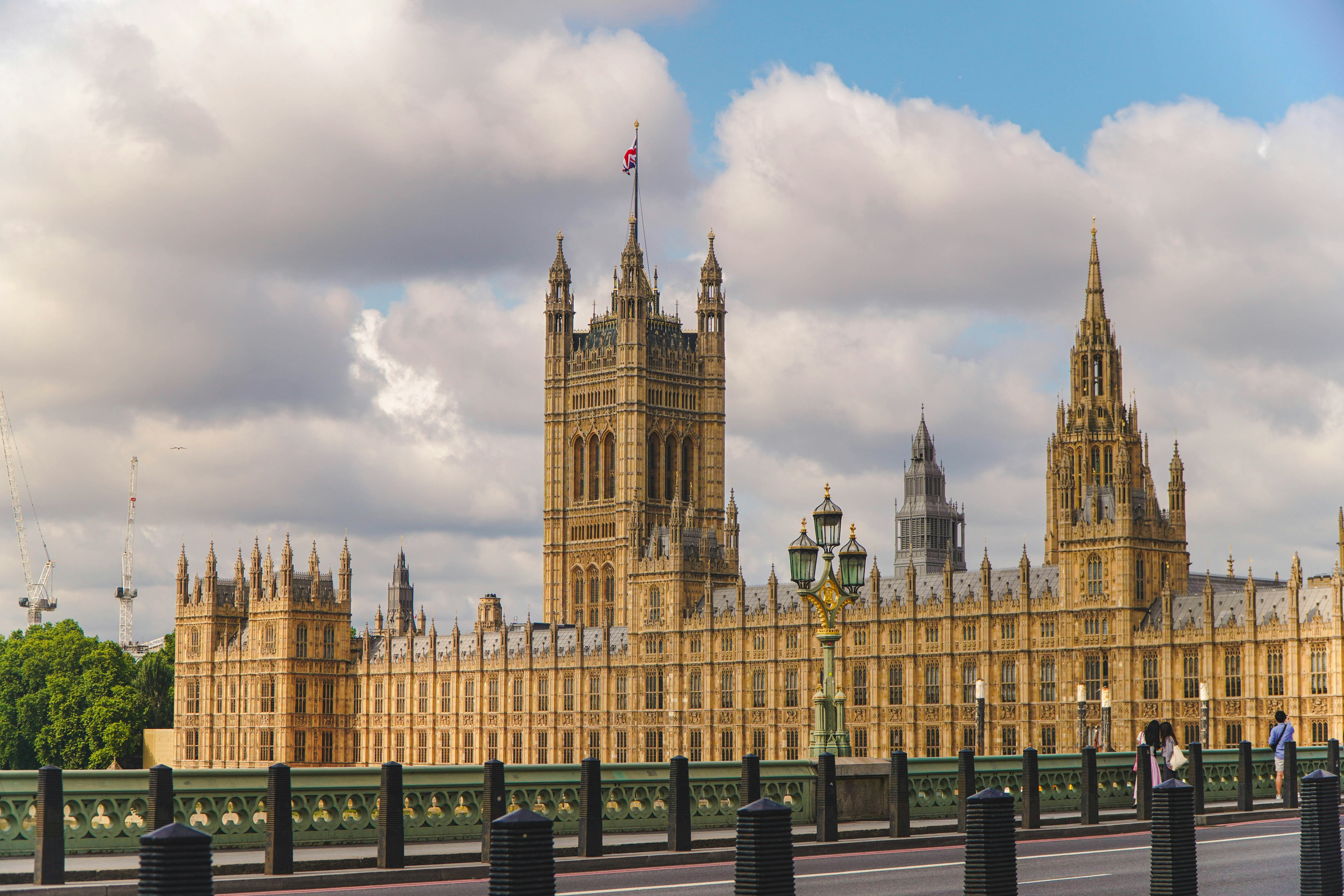 House of Parliament and a bridge in front with people on the street.