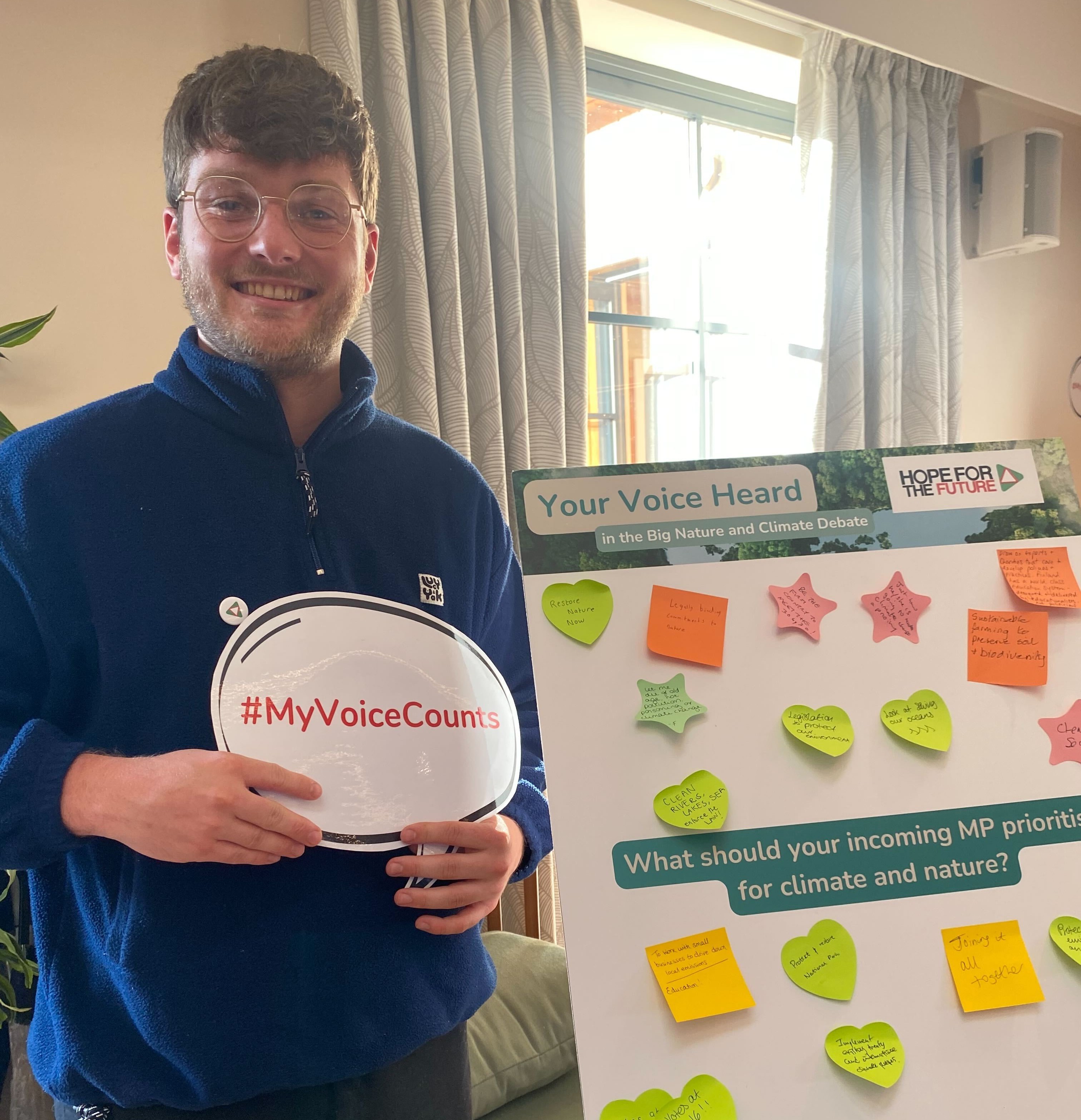 Man standing holding a sign that says my voice counts